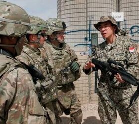 A Singaporean soldier gives an overview of the SAR 21 rifle to a group of US Army Soldiers 