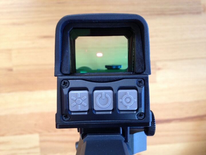 Left button: Brightness control. Center button: On/off. Right button: Reticle selection.