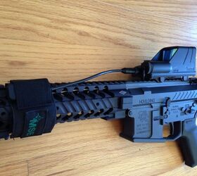 The PTT button inside of a provided nylon cover, secured by velcro on the forearm.