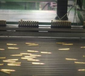 Completed rounds on the conveyor belt being picked up by a robotic arm which then places each round into the plastic tray, which when full, goes into the box you later purchase. 