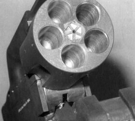 A close-up view of the gun's cylinder area. The cartridge extractor, in the center, was actuated by the curved lever within the carry handle.