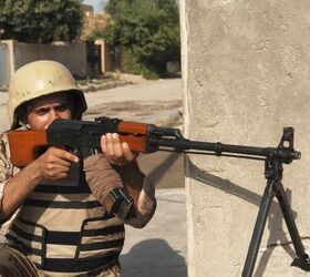 Original caption: 'An Iraqi army soldier provides security on a joint patrol with U.S. Army Soldiers from 3rd Squadron, 2nd Stryker Cavalry Regiment out of Vilseck, Germany, in the East Rashid district of Baghdad, Iraq.' He holds an RPK light machine gun which is based on the Kalashnikov assault rifle, but fitted with a longer, thicker barrel and bipod. Image source: commons.wikimedia.org
