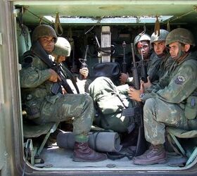 These marines inside an M113 armored personnel carrier are holding their standard 5.56x45mm Colt M16A2 rifles, in service since 1996. Note BFAs (Blank Firing Attachments) on two of the gun muzzles, indicating they're in an exercise.