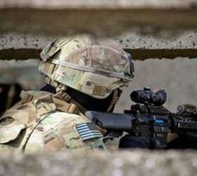 A soldier employing an M4 in a typical modern configuration, equipped with an ACOG optic and PEQ-15 infrared laser.