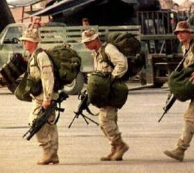 Three homeward-bound U.S. Army Rangers carry their bags and M-16 rifles toward a military transport plane at Mogadishu International Airport on Oct. 21, 1993, for the withdrawal from Somalia. (Hocine Zaourar/AFP/Getty Images)