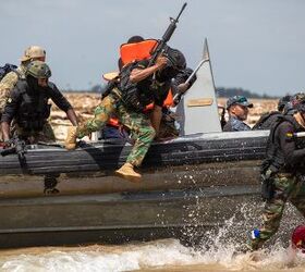 Members of the Ghana Armed Forces jump off a boat to take up fighting positions on a beach. (U.S. Army photo by Staff Sgt. Charles Brock)