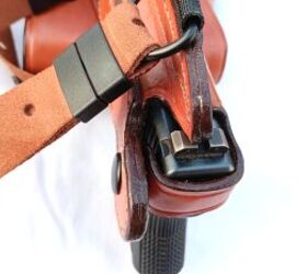 This retention strap is secured with a metal snap. The snap can be undone with the strong hand thumb during the draw.