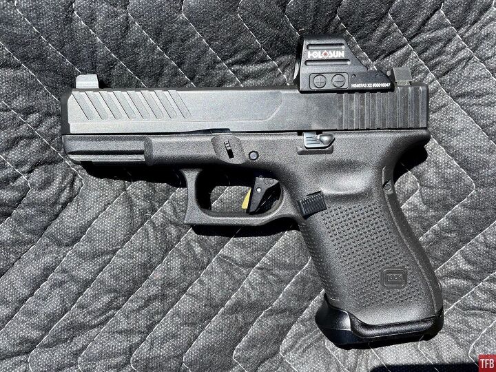 The Glock Timney Alpha trigger installed in a Gen 5 Glock 19. The trigger safety blade color is green.