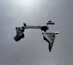 Glock stock trigger shoe, trigger bar, connector, trigger mechanism housing, and trigger return spring assembly.