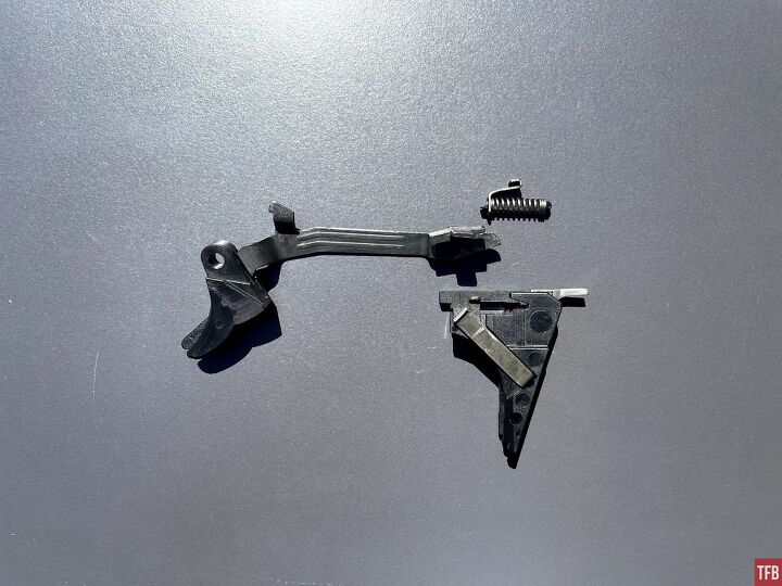 Glock stock trigger shoe, trigger bar, connector, trigger mechanism housing, and trigger return spring assembly.